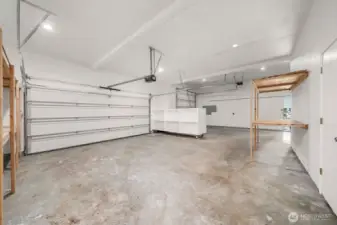 Overview of most of the 3 car garage. Complete with shelving and seperate entry into the upstairs where a MIL apt awaits.