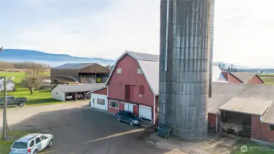 Classic hip roof barn, silo. The white painted portion is currently the milkhouse. In the distance is the machine shed and covered bunker