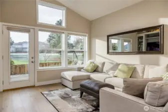 The bright and airy living space offers a peaceful perspective, directly overlooking the community putting green