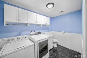 The laundry room also serves as a handy powder room for that guest suite. Spacious with loads of storage