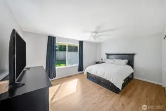 Large primary suite with ceiling fan, LVP flooring and large window to the rear yard