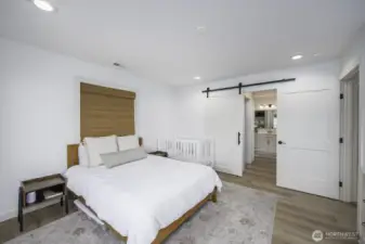 Notice the custom barn door that opens to the bathroom with a walk-in closet to the left