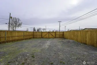 This graveled area is perfect for any parking or storage needs.  The double gate opens wide for a variety of needs