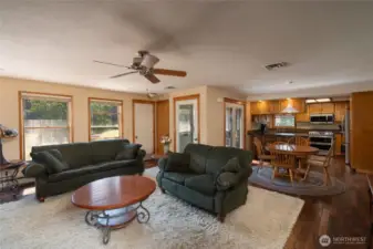 Cozy living area opens to kitchen and dining area. Dark Oak hardwood floors and Anderson double hung wood clad windows with low-e glass & screens. Vents in ceiling are air returns for woodburning stove with shroud located in basement.
