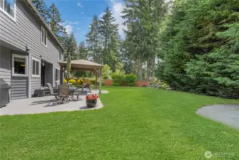 Stamped concrete patio with a charming gazebo creates an inviting outdoor space, perfect for relaxing or entertaining guests in style.