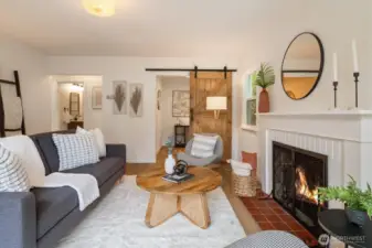 View of the living room from front window. Den pictured behind barn door.