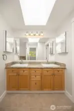 Double sink vanity with granite counters & tile floors.
