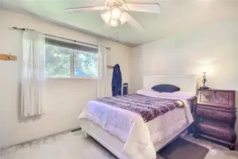 Master bedroom with private backyard view and attached private bathroom and beautiful fan/light.