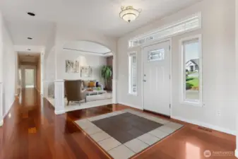 Talk about a grand entrance! This foyer has it all: a gorgeous leaded glass front door, portrait windows, and an upper accent window that lets the sunshine pour in. The two-tone tile inset against the Brazilian hardwood floors adds that wow factor we all crave. And can we take a moment for the arched pillared doorway? It leads you right to the den/open office/music room, making this entry not just pretty, but practical. Welcome to your fabulous new life!