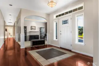 Talk about a grand entrance! This foyer has it all: a gorgeous leaded glass front door, portrait windows, and an upper accent window that lets the sunshine pour in. The two-tone tile inset against the Brazilian hardwood floors adds that wow factor we all crave. And can we take a moment for the arched pillared doorway? It leads you right to the den/open office/music room, making this entry not just pretty, but practical. Welcome to your fabulous new life!