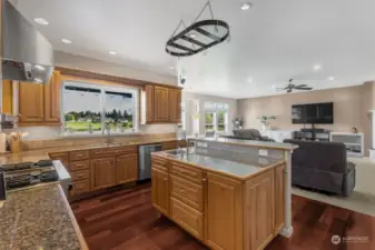 Cooking just became a social affair in this gorgeous kitchen! With a second sink on the island for all your prep needs and a charming pot holder hanging above, you’ll have everything at your fingertips. The raised bar seating invites family and friends to gather, making it easy to connect while you whip up your favorite dishes. And let’s not forget the stunning window view of the backyard and Mt. Rainier—a perfect backdrop for your culinary adventures.