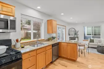 Kitchen with granite counters, appliances, and an extended breakfast bar. Open layout provides clear sightlines to the living area and dining space.