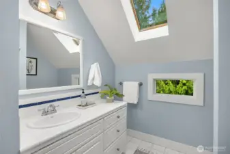 The upper bathroom includes a large vanity and skylight.