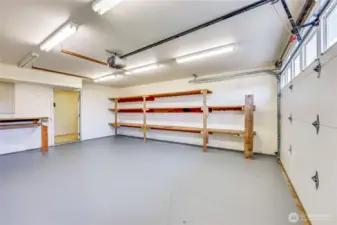 The large 2 car garage- there is tons of built in shelving here, plus a utility room beyond that door with lots more storage.