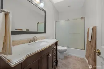 Main bath off 2nd bedroom and hallway. Tile flooring, granite counter on vanity and a skylight.