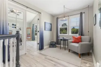 Sitting nook outside the primary suite. French doors access primary bedroom suite.