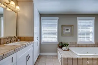 Spacious primary bath with double vanity, spa tub, walk-in shower