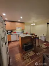 From the door to the DogDeck looking back into the kitchen and eating area. Just out of view to the right is the hallway that leads to the second full bathroom, laundry area, the primary bedroom and bath (currently used as an office) and the entry door.