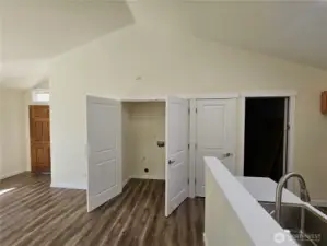 Family room looking at laundry room, front door pantry closet and garage entry