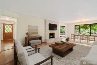 Living & Dining Room with views toward the large private backyard. Original Front Door Entry shown. Gleaming original oak hardwood floors & wood burning brick fireplace. Virtually staged to show potential of this space!