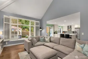 Oversized windows framed by plantation shutters overlooking the garden.