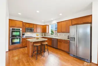 Kitchen boasts an abundance of rich wood cabinets, pantry and stainless appliances.