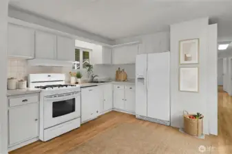 The bright and cheery kitchen has gas cooking and plenty of storage space. Plenty of space for a dining set as well! *Virtually Staged