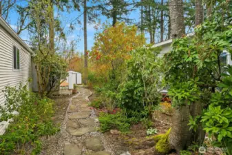 This lovely garden path with pavers leads to the back of the home. Enjoy the greenery, nature sounds and the open greenbelt space behind the home.