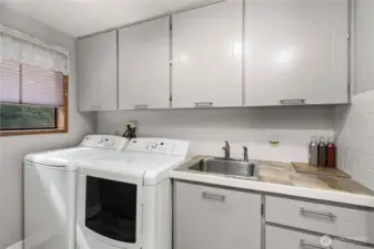 Laundry room with storage closet for brooms and a vacuum. But wait... there is a built-in vacuum system.
