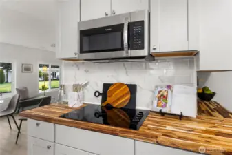 NEW glass-top range paired with a NEW stainless steel microwave & NEW backsplash adds modern style and everyday functionality to this beautifully updated kitchen.