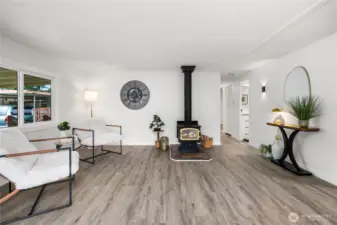 Versatile den with a cozy wood-burning stove & motion-sensored sconces create the perfect retreat for relaxing, reading, or enjoying a quiet evening at home.