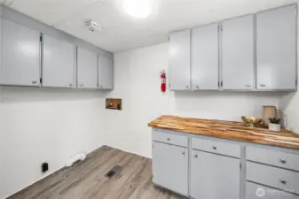 Spacious utility room offers NEW butcher block counters, freshly painted cabinetry w/new hardware & abundant counter space—ideal for storage, hobbies, or laundry organization. NEW hot water heater!