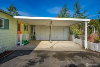 Covered side-by-side carport w/ 2 sheds offers convenient, protected parking & storage with easy access to the home.