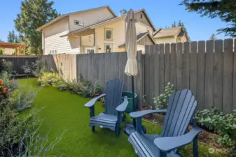 Backyard has plenty of space for seating and a beautiful astro turf lawn.