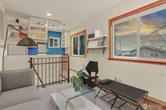 Cottage (North) home upper level living room with cork floors and southern exposure opens to kitchen.  Virtually staged photo.