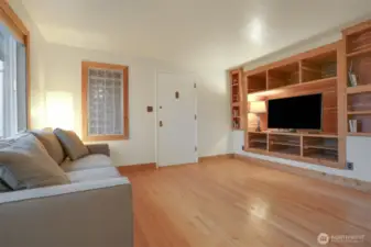 Main (South) home upper level living room with hardwood floors, bump out for entertainment center, woodstove and western exposure.