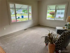 Living room with double windows, new carpet and all new paint.