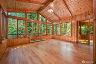 A spacious second living space on the main level brings the outside in. Lined with wood framed windows and wrapped by a beautiful deck. Sunroom off the far sliding door with beautiful territorial views.