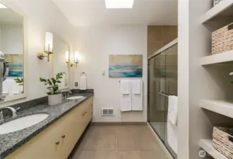 Primary bathroom features dual vanities and walk-in shower