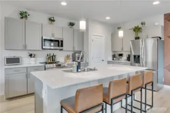 Kitchen with big island, pantry, stainless steel appliances & quartz counters ~