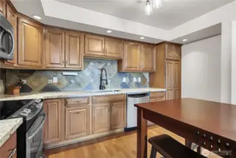 Stainless steel appliances, hardwood floors, granite countertops and counter to cabinets tile backsplash in the kitchen.