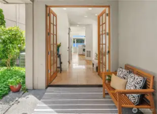 Enter the home through a covered entryway, garden on left with path to waterfront patio.
