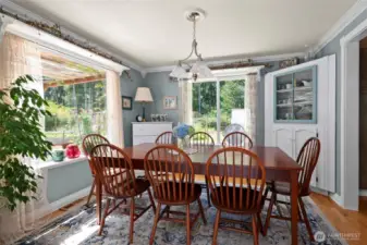 Beautiful dining room! Amazing amount of light, and soak in the garden charm. Custom built-in corner cabinet.