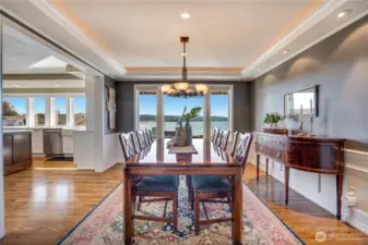 Seamless flow into the formal dining area featuring recessed ceiling detail with integrated cove lighting.