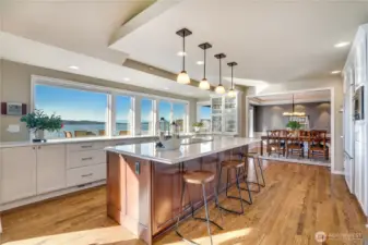 A designer kitchen remodel steals the show with a grand island, custom cabinetry, and top-tier appliances—seamlessly flowing into the beautifully appointed family room and out to the expansive view deck beyond.