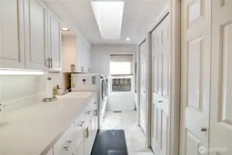 You’ll appreciate the spacious utility room—thoughtfully designed with ample cabinetry, expansive counters, and a built-in sink.