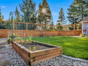 A new front yard features an 8’ deer-proof fence, sod lawn, paver patio, raised garden beds, and a welcoming sunroom entry—ideal for year-round enjoyment and gardening.