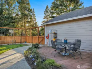 A new front yard features an 8’ deer-proof fence, sod lawn, paver patio, raised garden beds, and a welcoming sunroom entry—ideal for year-round enjoyment and gardening.