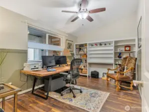 Bedroom #1 currently being used as an office space with built in cabinetry and wainscoting surround.