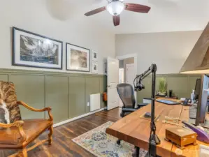 Bedroom #1 currently being used as an office space with built in cabinetry and wainscoting surround.